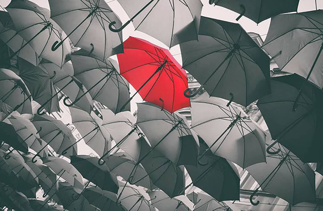 umbrellas in black and white but one is red